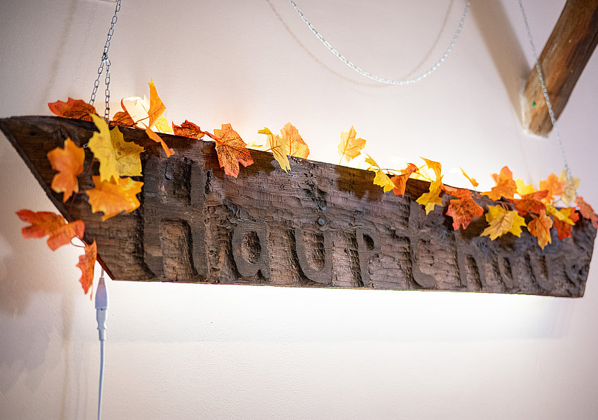 Holzschild mit dem Schriftzug Haupthaus